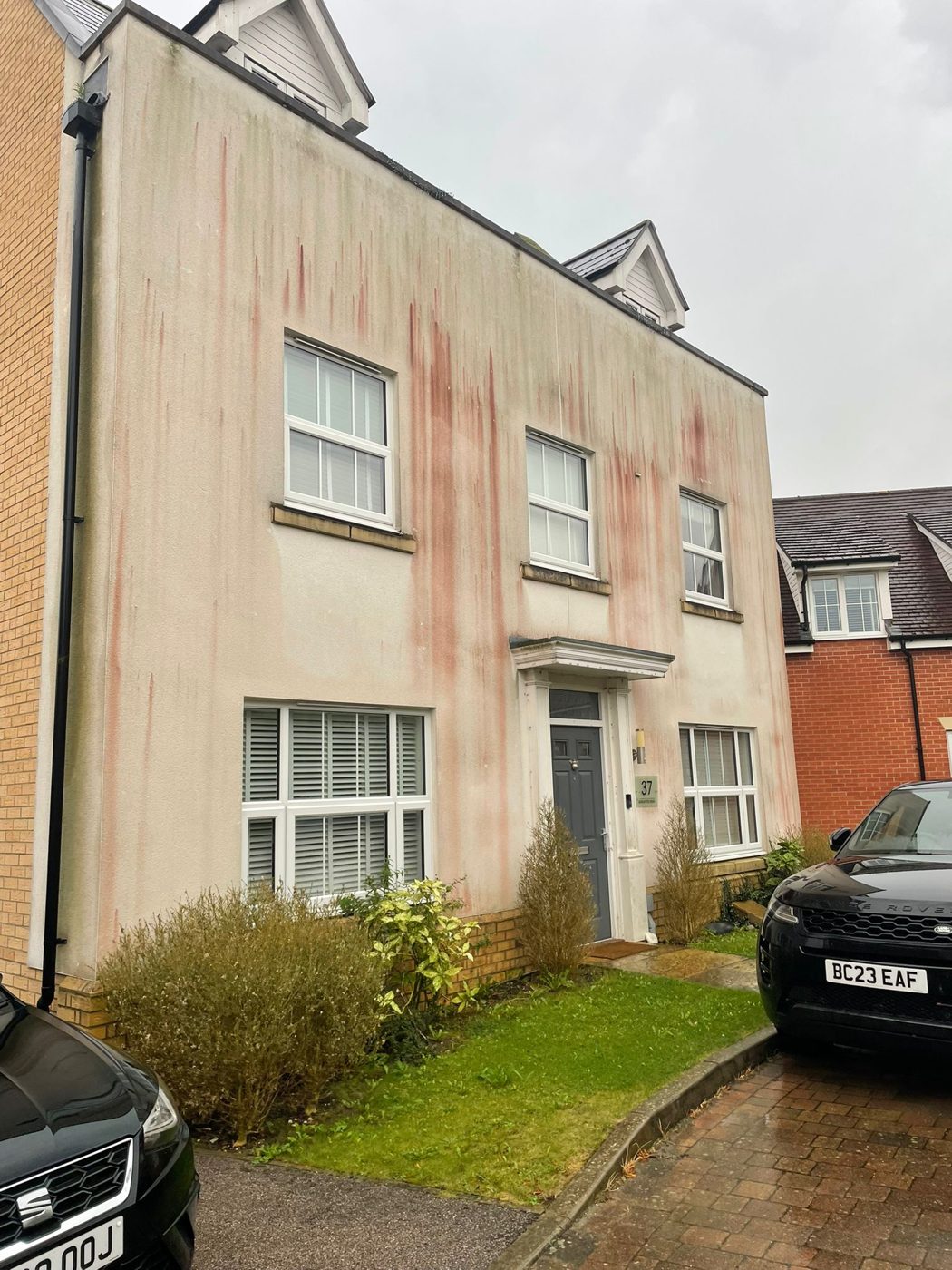 Render on a three-storey house before cleaning